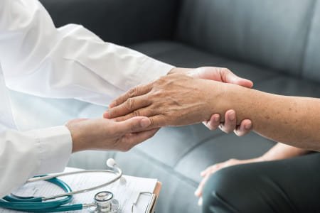 доктор держит за руку пациента