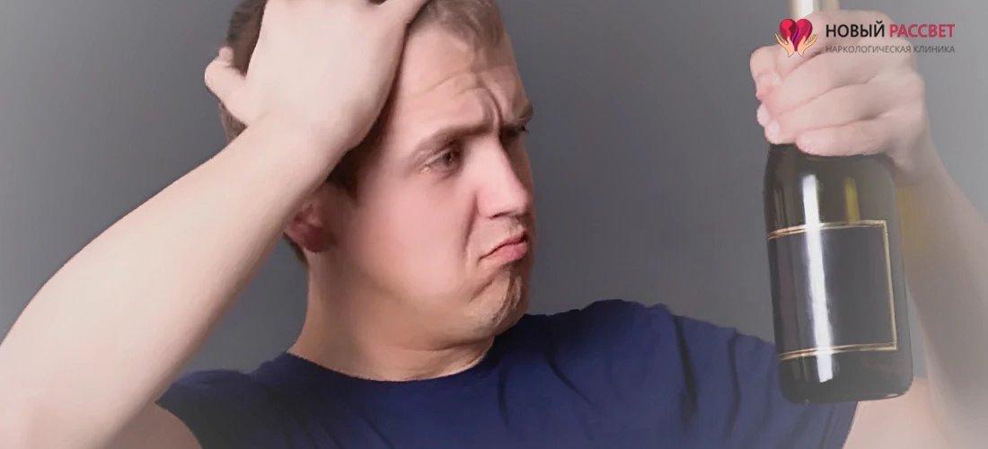 Мужчина с бутылкой в руке задумался